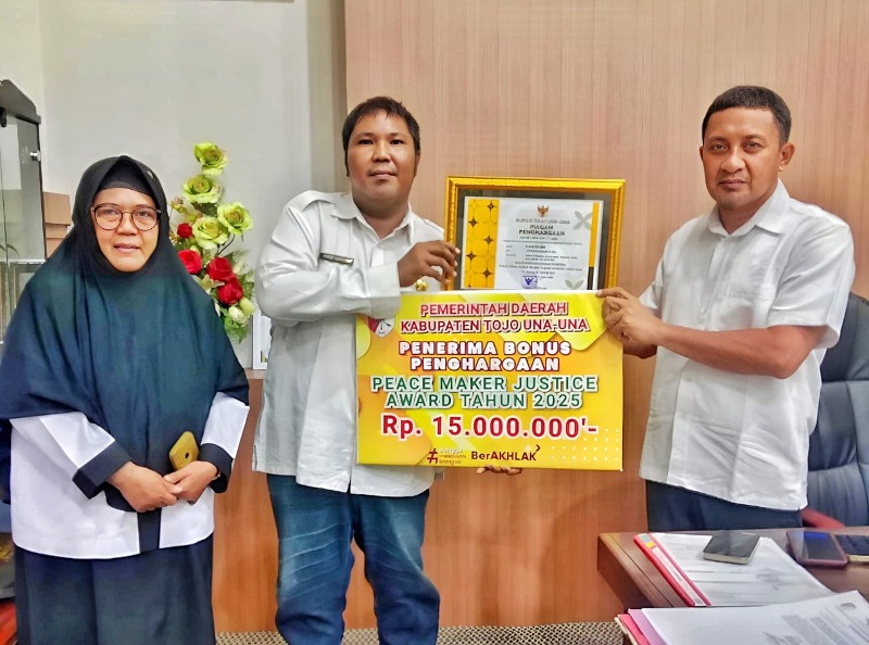 Bupati Touna, Ilham Lawidu Saat Menyerahkan Piagam Penghargaan dan Bonus Kepada Lurah Labiabae Sebagai Bentuk Apresiasi