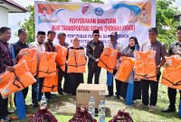 Bupati Ilham Lawidu Didampingi Wakil Bupati Surya Lapasiri Saat Menyerahkan Bantuan Perahu Transportasi Siswa Yang Tinggal di Pulau Terpencil 