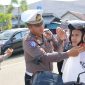 Kasatlantas Polres Touna, Siswanto Saat Memakaikan Helm Gratis Kepada Pengendara Yang Melintas di Jalan Mohamad Hatta Kecamatan Ampana Kota