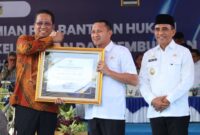 Foto : Bupati Touna, Ilham Lawidu Saat Menerima Penghargaan Posbankum Dari Menteri Hukum.