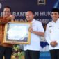 Foto : Bupati Touna, Ilham Lawidu Saat Menerima Penghargaan Posbankum Dari Menteri Hukum.