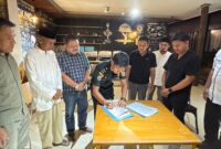 Bupati Touna, Ilham Lawidu Saat Melakukan Penandatanganan Berita Acara Serah Terima Lokasi Pekerjaan Pembangunan Kampung Nelayan Merah Putih.