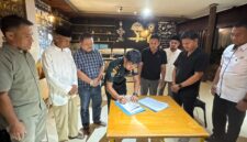 Bupati Touna, Ilham Lawidu Saat Melakukan Penandatanganan Berita Acara Serah Terima Lokasi Pekerjaan Pembangunan Kampung Nelayan Merah Putih.
