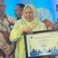 Wakil Bupati, Surya Lapasiri Saat Menerima Piagam Penghargaan Jamsostek Award.