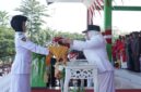 Wakil Bupati Surya Lapasiri Saat Menyerahkan Bendera Pusaka Merah Putih Kepada Anggota Paskibraka Untuk di Kibarkan Pada Upacara Peringatan Hari Kemerdekaan Republik Indonesia.