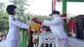 Wakil Bupati Surya Lapasiri Saat Menyerahkan Bendera Pusaka Merah Putih Kepada Anggota Paskibraka Untuk di Kibarkan Pada Upacara Peringatan Hari Kemerdekaan Republik Indonesia.