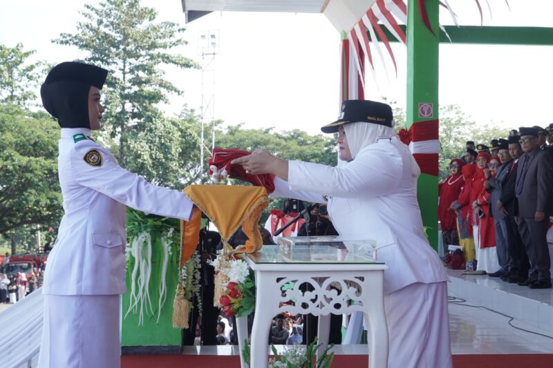 Wakil Bupati Surya Lapasiri Saat Menyerahkan Bendera Pusaka Merah Putih Kepada Anggota Paskibraka Untuk di Kibarkan Pada Upacara Peringatan Hari Kemerdekaan Republik Indonesia.