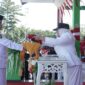 Wakil Bupati Surya Lapasiri Saat Menyerahkan Bendera Pusaka Merah Putih Kepada Anggota Paskibraka Untuk di Kibarkan Pada Upacara Peringatan Hari Kemerdekaan Republik Indonesia.