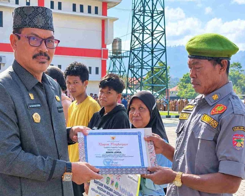 Sekda Touna, Alfian Matajeng Saat Menyerahkan Bantuan Pangan Daerah Melalui Program Berani Sejahtera Sekaligus Penghargaan Dari Gubernur Sulawesi Tengah.